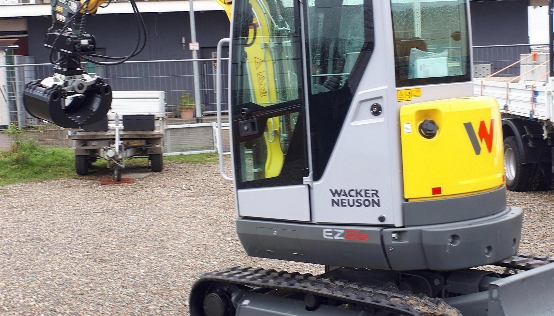 Minibagger mit Greifer bei Erdarbeiten auf einem Grundstück
