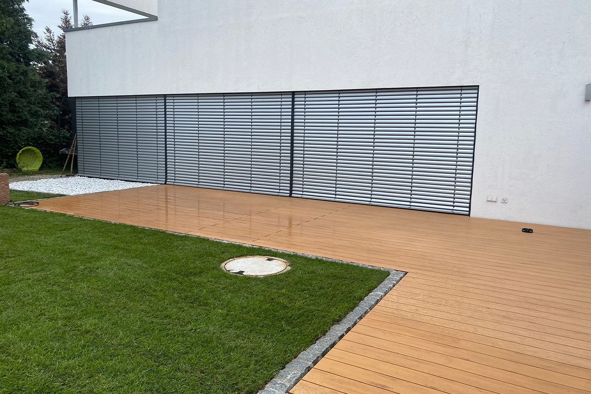 Neu angelegter Garten mit Holzterrasse und Rollrasen an einem modernen Wohnhaus